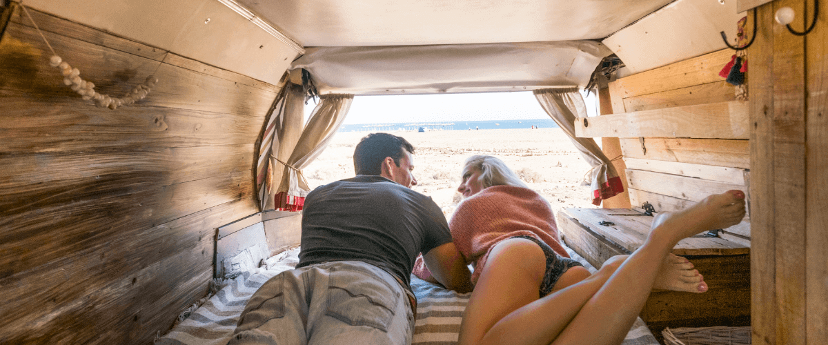 man and woman laying in camper van